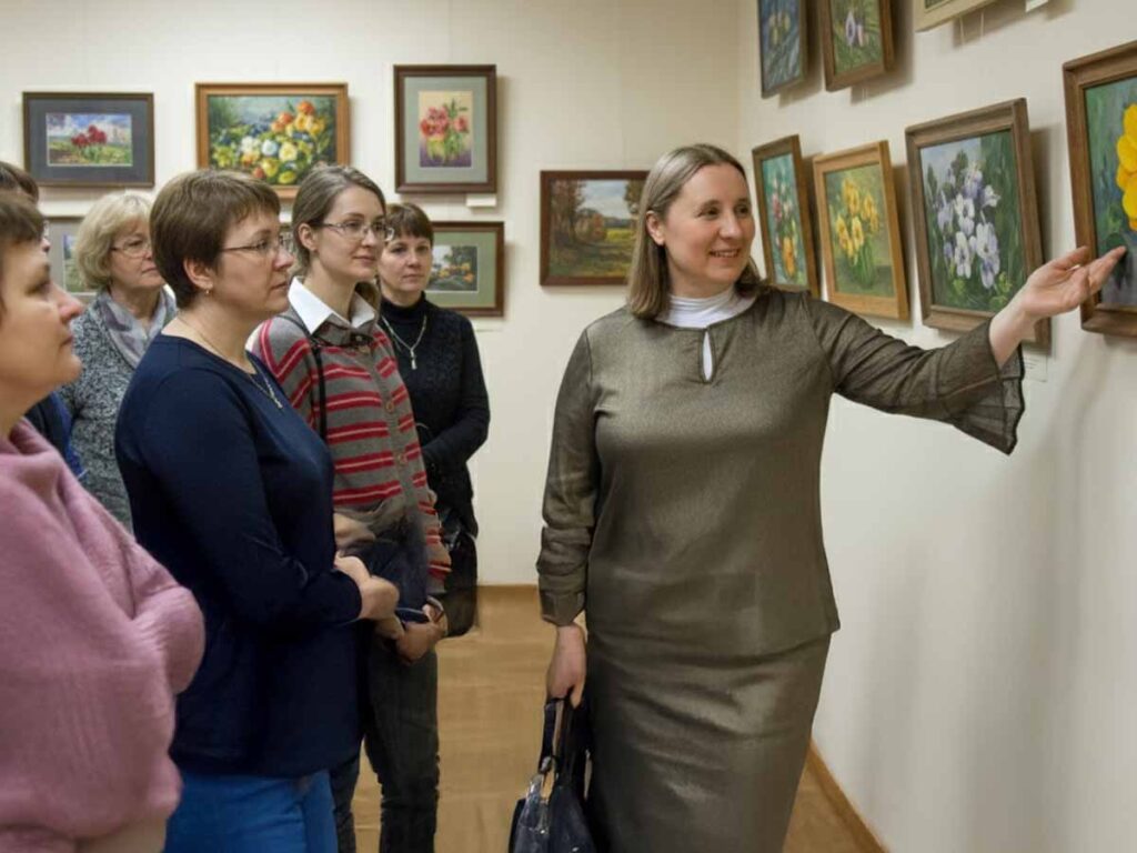 Art educator Olga Shmatova with students at their artwork exhibition